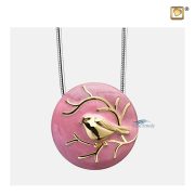 Round pendant for ashes with gold bird on pink enamel