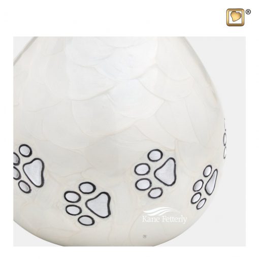 Urne pour animal domestique en aluminium blanc en forme de larme décorée de empreintes de pattes argentées.