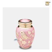 Brass miniature urn with bird and foliage motifs on a pink enamel surface