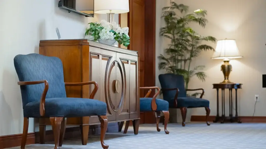 Espace d’assise élégant au salon funéraire Kane Fetterly à Montréal, doté d’un mobilier classique, d’un éclairage doux et d’un arrangement floral.